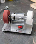 Knockout Bench Top Electric Grinding Machine With Rock Solid Anti Slip Base For Smooth Metal Polishing And Heavy Duty Rust Removal Precision Edge Control Tool, compact with red and white polishing wheels.