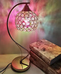 Colorful stained glass lamp next to stacked books on a table