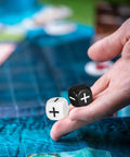 Hand holding black and white dice from 24 Piece Addition Subtraction Dice Set For Classroom Math Practice With 16mm Black And White Acrylic Symbols Featuring Plus And Minus Signs Fun Hands On Manipulatives For Kids Learning Games And Interactive Arithmetic Lessons.