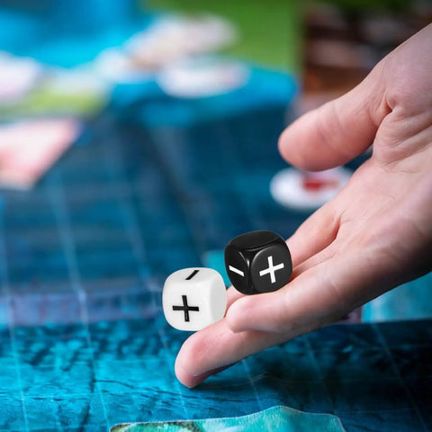 Hand holding black and white dice from 24 Piece Addition Subtraction Dice Set For Classroom Math Practice With 16mm Black And White Acrylic Symbols Featuring Plus And Minus Signs Fun Hands On Manipulatives For Kids Learning Games And Interactive Arithmetic Lessons.