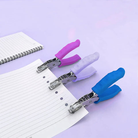 Three-pack one hole puncher for paper crafts with purple soft grip handle, shows metal body, punches on lined paper, quarter inch hole size.
