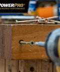 Premium Exterior Wood Screws For Decking And Outdoor Projects Built Tough Bronze Finish Size Nine By Two And A Half Inch All Purpose Deck Screws With T-25 Star Bit Included 100 Pack Epoxy Coated For Superior Corrosion Resistance being drilled into a wooden plank.