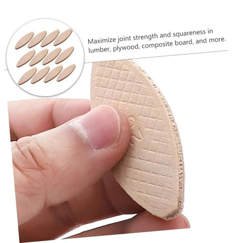Close-up of hand holding a piece from 100 Pcs Beech Wood Biscuits Set For Woodworking
