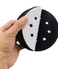 Hand holding Five Pack 5 Inch Soft Density Interface Pads with Eight Hole Design and Hook and Loop Backing, showing sponge cushion.