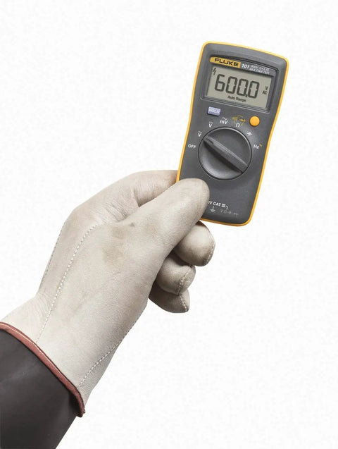 Gloved hand holding Compact Digital Multimeter With 6000 Count Display And 600V AC And DC Range And Accurate Voltage And Resistance Readouts