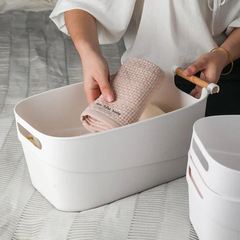 Top Shelf White Plastic Storage Basket With Lidless Opening For Zero Fuss Organization And Straight Up Space Saving Efficiency Ideal For Cozy Living Room Or Bedroom Vibes, holding a rolled towel.