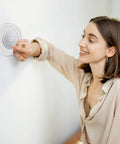 Woman adjusting thermostat with Silicone Backplate Wall Mount For WiFi Thermostats, Fingerprint Resistant Finish