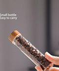 Keep Your Daily Coffee Run Fresh With This Top Tier Airtight Single Dose Bean Cellar Crafted From Genuine Walnut Wood And Clear Glass Tubes Designed To Be Hella Dope On Any Modern Counter While Blocking Out That Stale Funky Taste, small clear glass tube with walnut cap holding coffee beans.