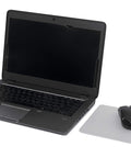 Laptop beside Precise Mouse Pad With Repositionable Adhesive Back For Optical Mice At High Speeds, extends battery life, ultra thin design.