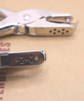 Close-up of ergonomic handheld dual hole punch set with one quarter inch and one eighth inch holes for DIY crafts and office use