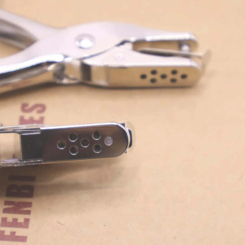 Close-up of ergonomic handheld dual hole punch set with one quarter inch and one eighth inch holes for DIY crafts and office use