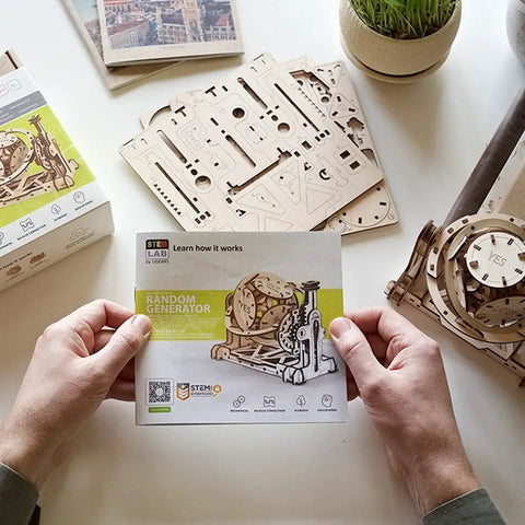 160 Piece Wooden Interlocking Puzzle Kit With Laser Cut Sustainably Sourced Plywood Real Wood Scent Easy Sanding Or Wax Finish Clear Manual Built For Brain Teasers And Creative Hands On Fun, boxed kit held over wooden puzzle parts