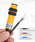 E3F-DS10P2 Photoelectric Sensor For Industrial Automation held in hand, showing exposed wires for connection.