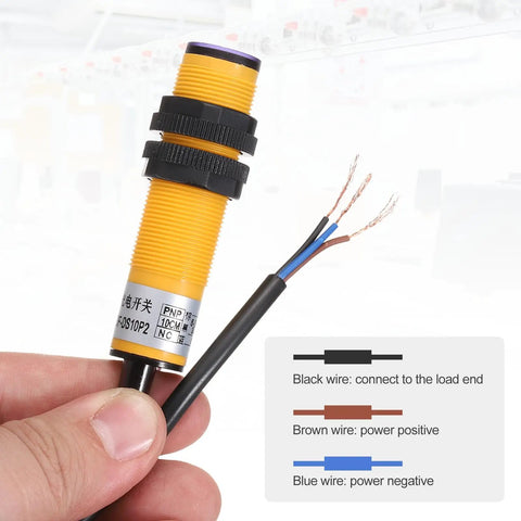 E3F-DS10P2 Photoelectric Sensor For Industrial Automation held in hand, showing exposed wires for connection.