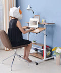 Height Adjustable Overbed Table With Smooth Rolling Casters, Sit To Stand Laptop Desk, Ergonomic Steel Frame Cart For Bed Or Couch in use with a person typing.