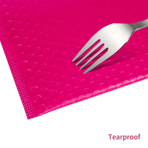Close-up of a fork on pink bubble mailer, showing tearproof cushioning. Pink Bubble Mailers 8.5x11 Inch 30 Pack Waterproof Padded Envelopes.