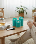 Turquoise Real Wax Flameless Candles Set Of 3, teal LED pillars on table, living room, relaxed ambiance with tea and book