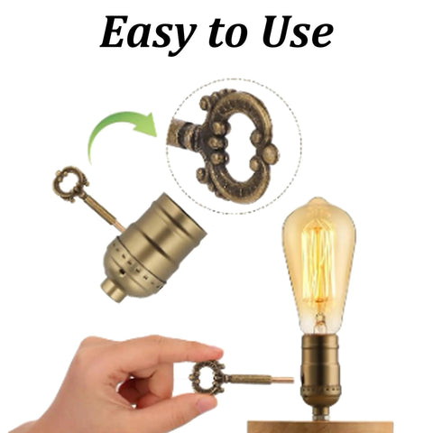 Two antique-brass lamp turn knobs with ornate keys for table or floor lamps; metal socket replacement knobs