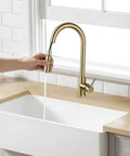 Sink Faucet,360°Pull-Out Spray,Brushed Steel Hot and Cold Rotation (Gold) in use over a white sink with water flowing.