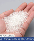 Hands holding clear polyurethane beads, raw material for Clear PU Pneumatic Tubing 4mm Outer Diameter by 2.5mm Inner Diameter.