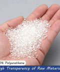 Clear polyurethane pellets held in a hand; small, translucent beads.
