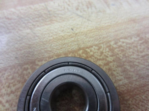 Close-up of 6200Z single-shielded deep-groove ball bearing, 10 mm ID x 30 mm OD x 9 mm width, on a wooden surface.