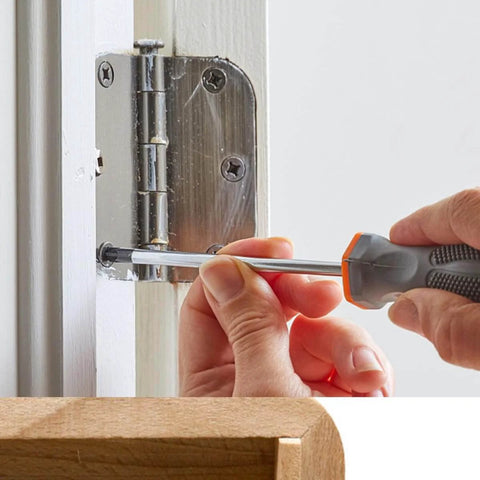 Person installing durable mini hinges for wooden boxes and jewelry boxes with nails in silver copper finish on a white door.
