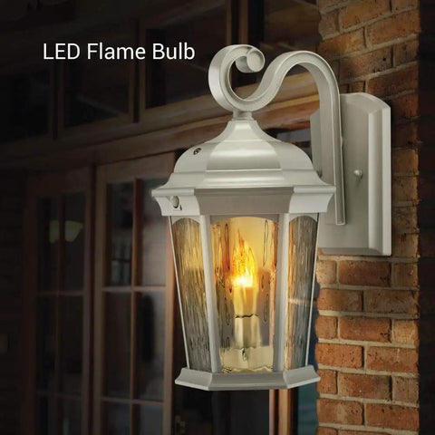 Lit Flickering Flame Lantern With Frosted Glass And Integrated Security Light 3000K Warm Glow Photocell And Motion Sensor Dusk To Dawn Outdoor Wall Lantern With Oil Rubbed Bronze Housing mounted on brick wall