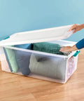 Slay Your Storage Goals With This Badass Set Of Plastic Latching Storage Bins Featuring Secure Snap Lids, Includes 106 Qt And 64 Qt Totes For Closet Decluttering, Garage Organization, And Keeping Bugs At Bay. A clear storage bin filled with pillows and blankets, featuring a secure snap lid.