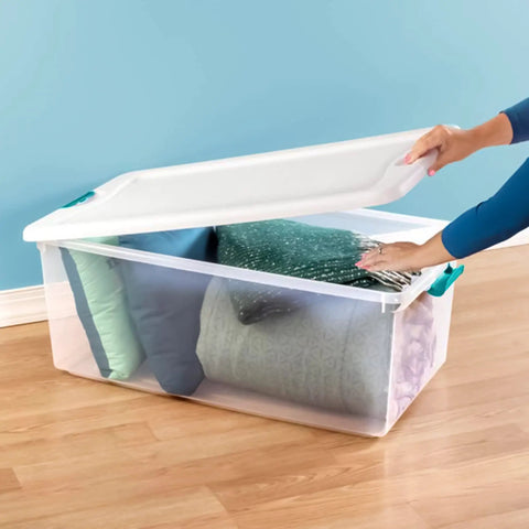 Slay Your Storage Goals With This Badass Set Of Plastic Latching Storage Bins Featuring Secure Snap Lids, Includes 106 Qt And 64 Qt Totes For Closet Decluttering, Garage Organization, And Keeping Bugs At Bay. A clear storage bin filled with pillows and blankets, featuring a secure snap lid.
