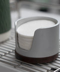 Slick Swivel Coffee Filter Paper Holder And Brewing Tool Caddy displays 120 stacked round papers in a sleek gray design.