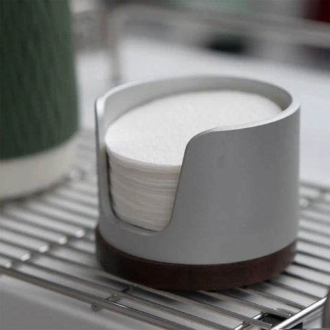 Slick Swivel Coffee Filter Paper Holder And Brewing Tool Caddy displays 120 stacked round papers in a sleek gray design.