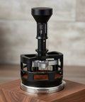 Slap On This Game Changing Espresso Pin Distributor And Coffee Wedge Tool That Knocks Out Clumps And Spreads Grounds Flawlessly For Barista Level Shots Without Breaking A Sweat At Home Or The Cafe In Sleek Black And 58mm on a wooden base.