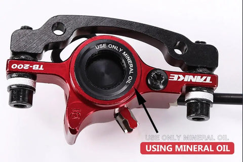 Close-up of Heavy Duty Hydraulic Disc Brake Kit For Mountain Bikes showing red caliper and instructions for mineral oil use.