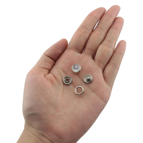 Hand holding 30 Sets Of 10mm White Pearl Snap Buttons And Metal Ring Snaps Popper Stud Fasteners Kit For Leather Bags Luggage Clothing Shoes DIY Crafts