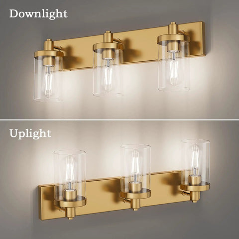 Slick Gold Vanity Light With 3 Lights For Bathroom Over Mirror Modern Wall Sconce With Clear Glass Shades Durable Aluminum Construction 24.5 Inch Long Vanity Lighting Fixture No Bulbs Included shown in downlight and uplight installations.