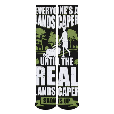 Knee-high socks with humorous landscaper text graphic, featuring a silhouette of a person mowing grass on a black and green background.