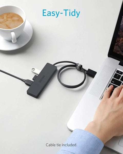 4 Port USB 3.0 Hub For Laptops And PCs, Ultra Fast 5Gbps Data Transfer, Turns One USB Port Into Four, USB Splitter For Desktop Or Travel, Charging Not Supported connected to a laptop on a desk, cable tie included.
