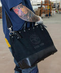 Person carrying Deluxe 16 Inch Canvas Tool Bag With 13 Pockets And Detachable Shoulder Strap Large Heavy Duty Organizer For Tools