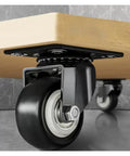 Close-up of Beefy Heavy Duty Caster Wheels With Brakes 4 Pack Rubber Wheel Stem Casters under furniture on a hard floor.