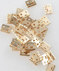 Mini Brass Hinges Set, 50 Pack For Small Craft Doors And Boxes, Tiny Cabinet Furniture Hardware scattered on white surface