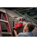 Man using Heavy Duty 1-5/8 Inch Magnetic Drill Base For Milwaukee Power Tools on 1/4 inch steel with a ladder.