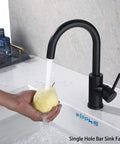 Person rinsing a pear under Matte Black Bar Sink Faucet With Single Hole Design in a kitchen setting