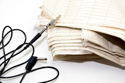 Front view of a 20-foot grounding cable with plug and metal alligator clip beside folded beige fabric.