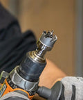 Close-up of a drill using Heavy Duty Hole Cutter Kit With Carbide Cutters And Two Pilot Bits In Rust Proof Molded Plastic Case Eight Piece Workhorse Set For Fast Precise Holes In Stainless Steel Mild Steel Iron Copper And Brass Up To Three Sixteenth Inch Thick on metal sheet.