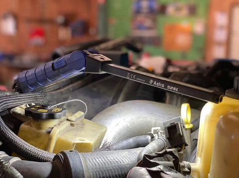 Double-Sided Folding LED Work Light With 1000 Lumen Flood illuminating an engine bay in a workshop setting