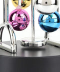 Close-up of Battery Powered Newton Pendulum Ball Desktop Toy with colorful mirrored balls on a plastic base, Newton's Cradle style.
