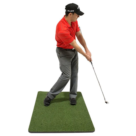 Golfer practicing swing on green mat with iron club using Chip Stix Golf Swing Trainer Aid Chip N Pitch Mastery Black And Green