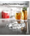 Grab And Go Countertop Pellet Ice Maker With Sturdy Handle And Single Knob Self Cleaning Delivers Thirty Five Pounds Of Fresh Nugget Ice In Under Fifteen Minutes For Easy Patio Parties And Weekend Chilling with nugget ice and drinks on a countertop.