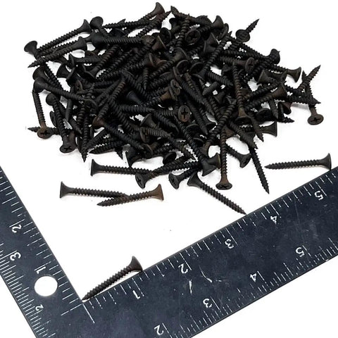 Pro Grade Drywall Screws For Light Gauge Steel Studs Size Six By One And A Quarter Inch scattered over a ruler.